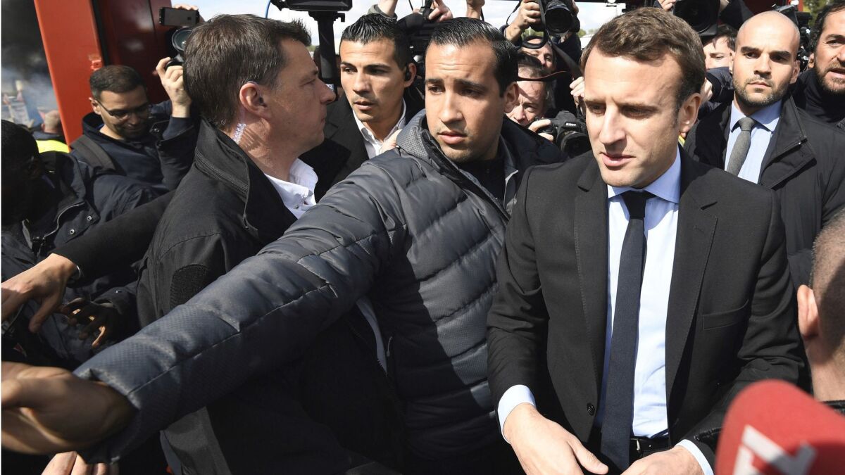 Then-presidential candidate Emmanuel Macron, right, and his bodyguard, Alexandre Benalla, arrive outside the Whirlpool home appliance factory in Amiens, northern France, on April 26, 2017.