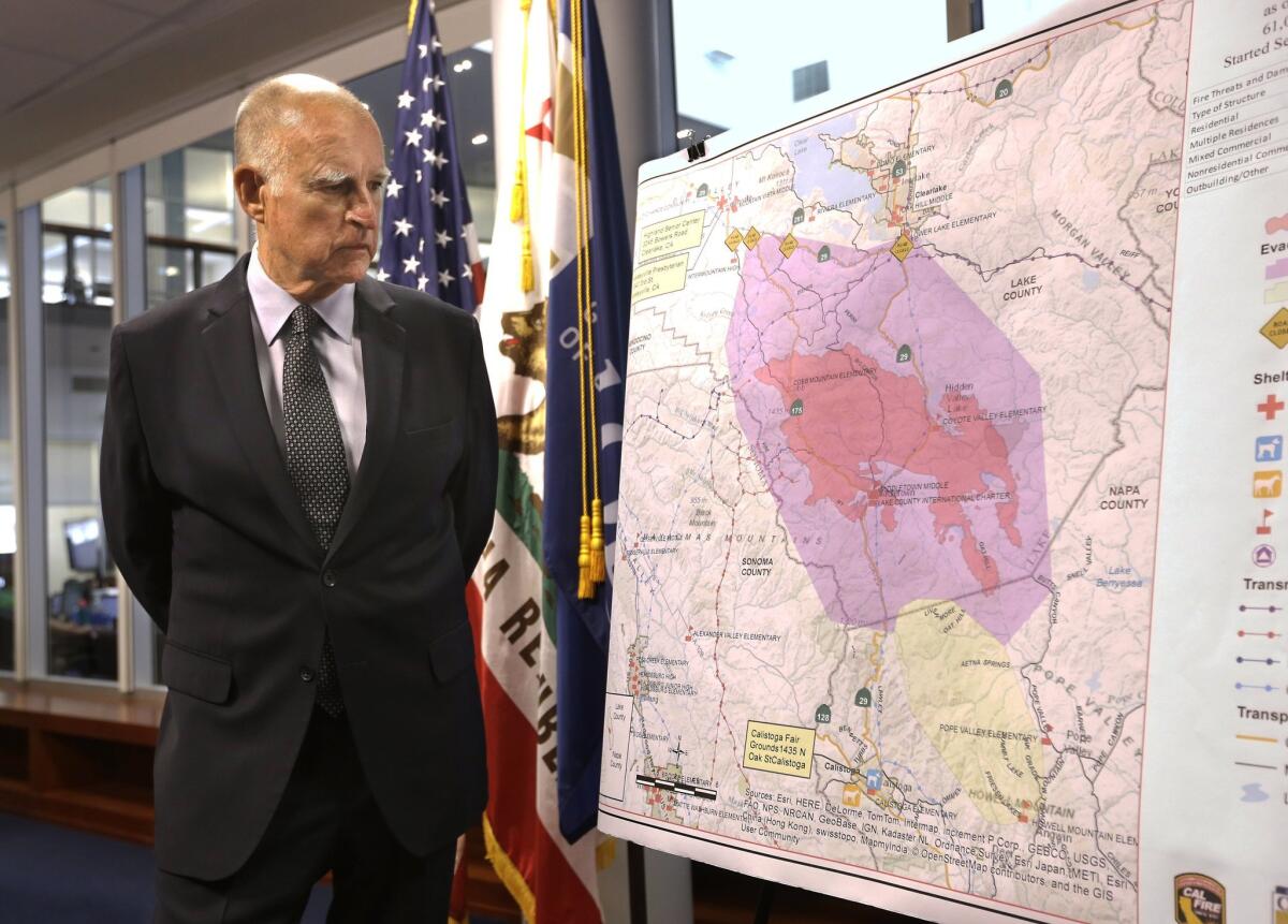 Gov. Jerry Brown studies a map showing the Valley fire while getting an update on the state's fire situation at the Governor's Office of Emergency Services in Rancho Cordova, Calif., on Monday.