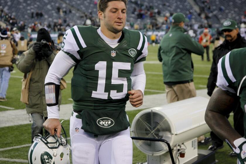 Tim Tebow walks off the field after the Jets' loss to the San Diego Chargers on Sunday.