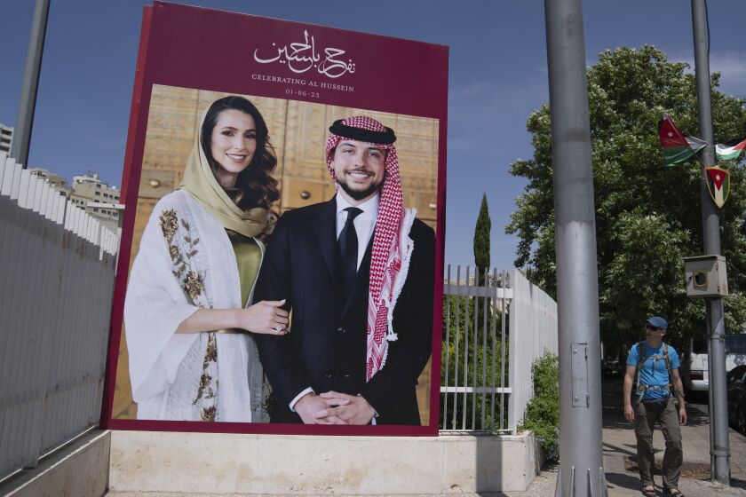 A poster with pictures of Crown Prince Hussein and his fiancee, Saudi architect Rajwa Alseif is posted at the main road in down town Amman, Jordan, Tuesday, May 30, 2023. Crown Prince Al Hussein bin Abdullah II, 28, and Rajwa Alseif, 29, are to be married on Thursday at a palace wedding in Jordan, a Western-allied monarchy that has been a bastion of stability for decades as Middle East turmoil has lapped at its borders. (AP Photo/Nasser Nasser)