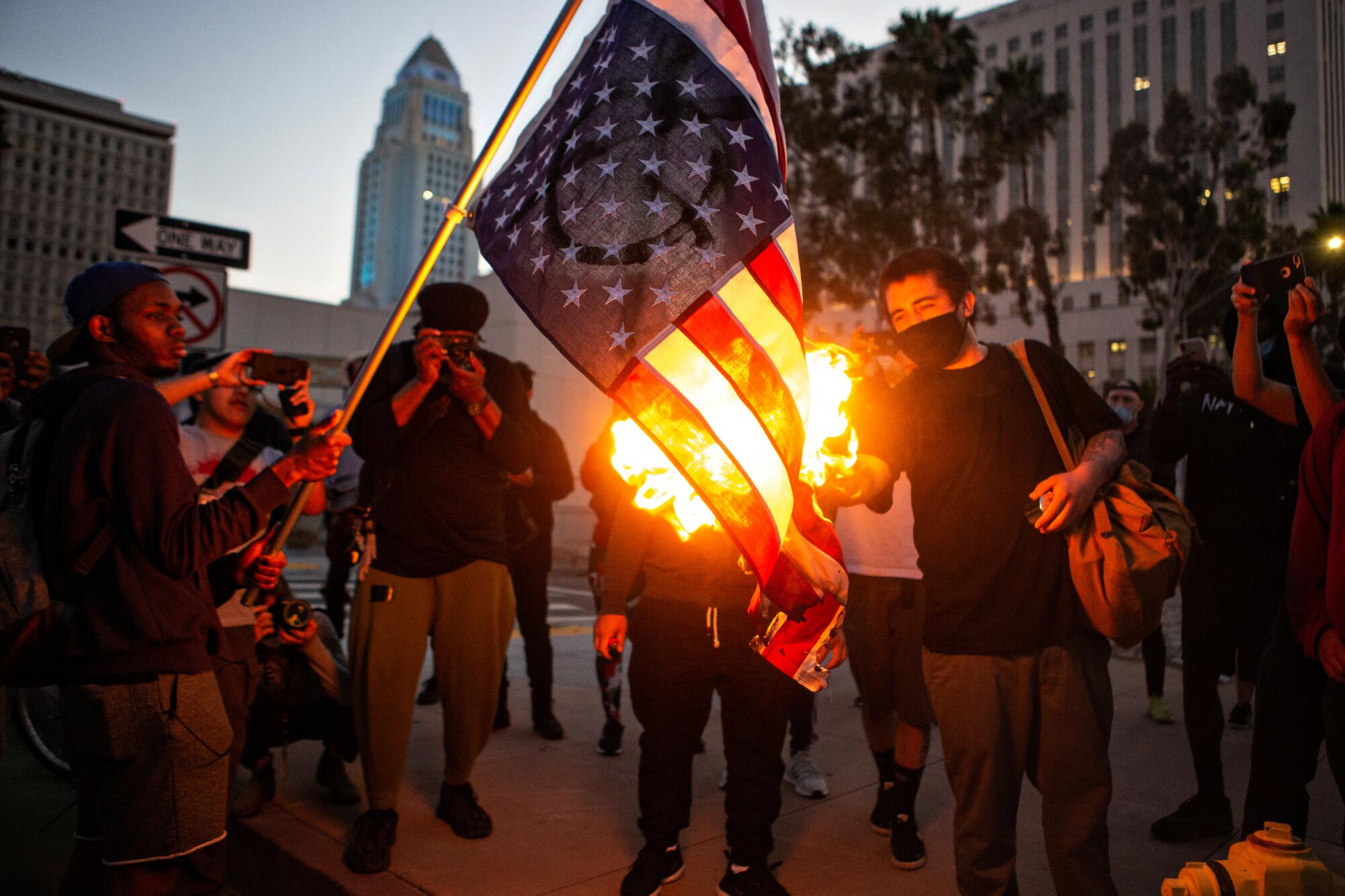 Protesters in downtown Los Angeles burn an American flag to protest the killing of George Floyd by police in Minneapolis.
