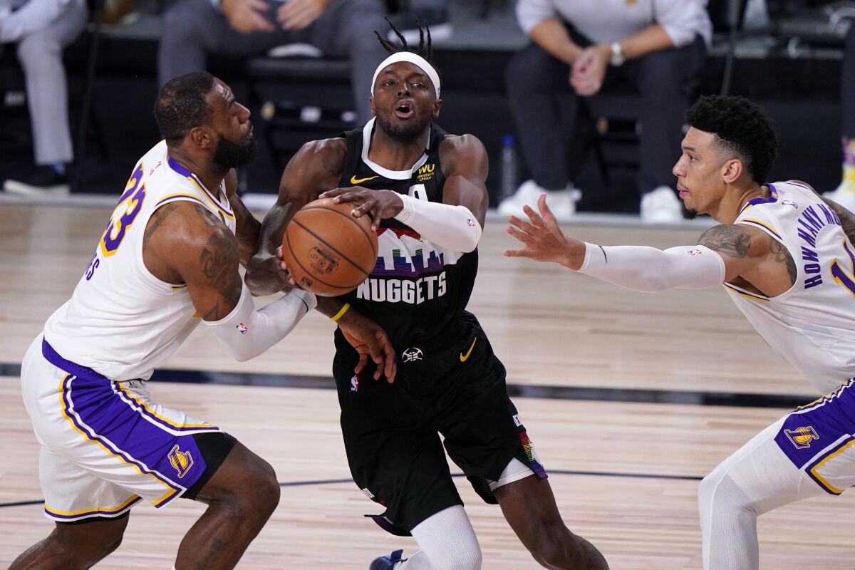 Nuggets forward Jerami Grant tries to drive between Lakers forward LeBron James and guard Danny Green during Game 3.