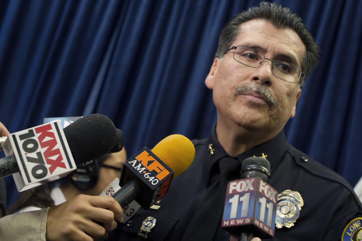 Long Beach Police Chief Robert Luna stands in front of microphones in 2014 after being appointed as the new chief