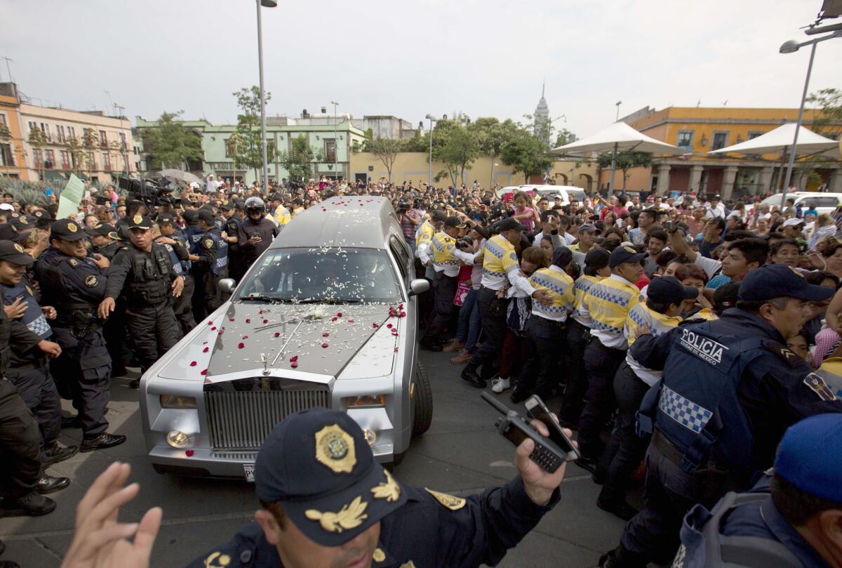 Una carroza fúnebre con los restos del cantante mexicano Joan Sebastian recorre la Plaza Garibaldi durante una procesión funeral en la Ciudad de México, el jueves 16 de julio del 2015. El músico murió el lunes tras una larga lucha con el cáncer, a los 64 años. (AP Foto/Eduardo Verdugo)