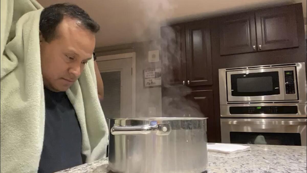 Alex Melo uses a steaming pot for a nebulizing treatment at his home in York, Maine.