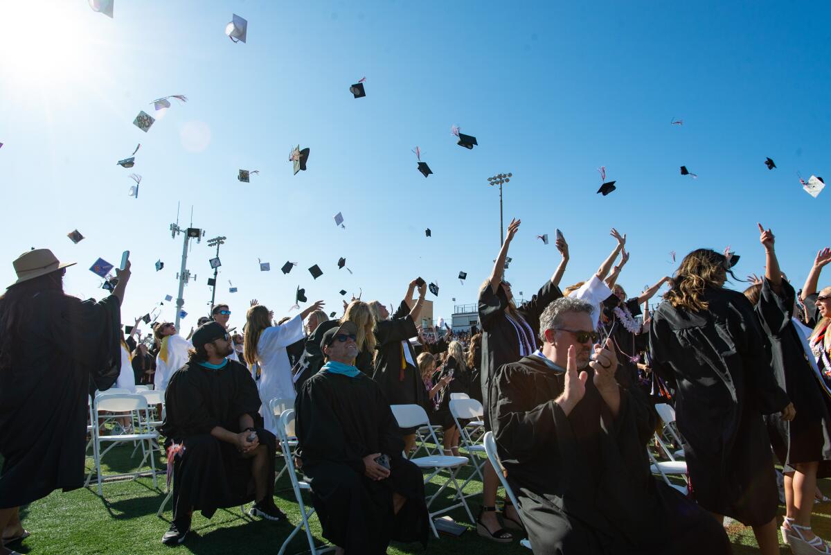 Seniors toss their caps into the air upon confirmation of their graduation from Huntington Beach High School on Wednesday.