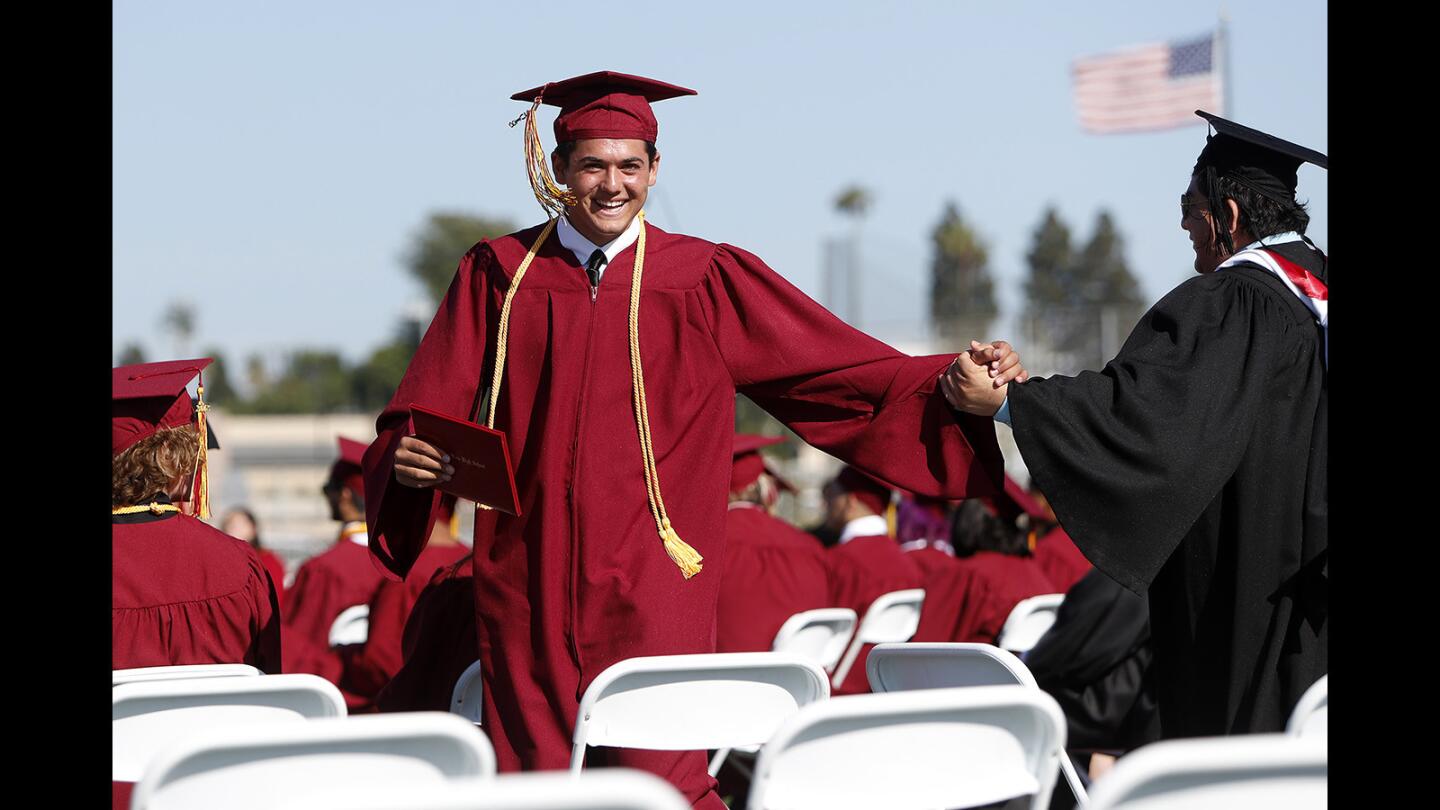 Graduate Christian Djurasevic, left, is congratulated by Jose Camey, boys' soccer head coach and Spanish teacher, during Ocean View High School's commencement ceremony in Huntington Beach on Wednesday, June 13.