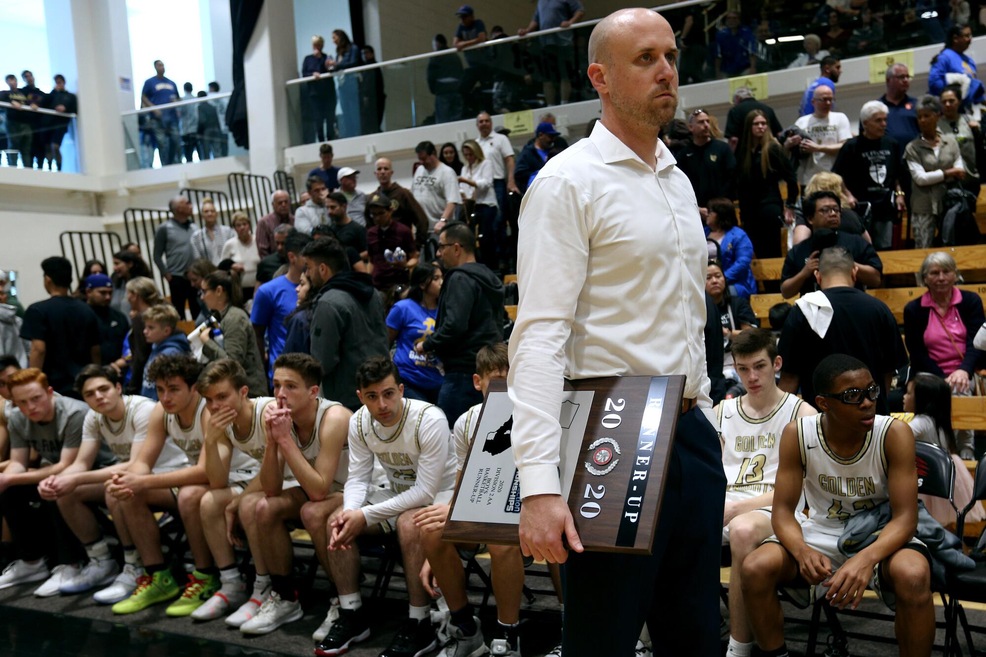 St. Francis boys' basketball coach Todd Wolfson holds the Southern Section Division 2-AA runner-up plaque last year.