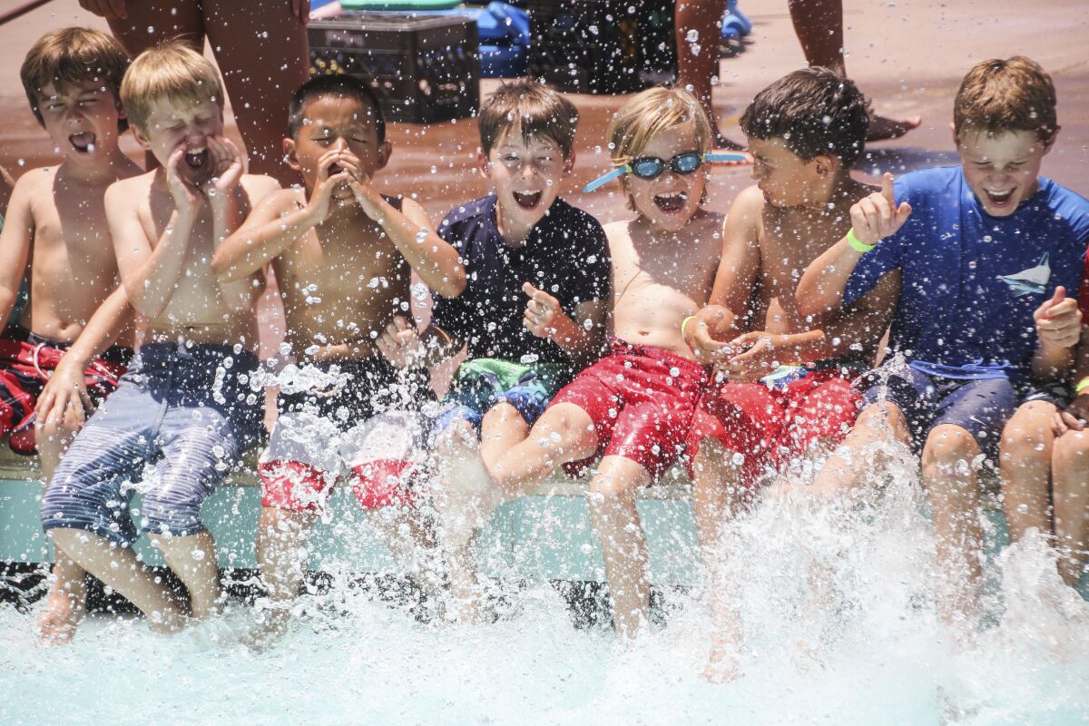 The photo released by the American Camp Association shows young boys splashing at the Tom Sawyer Camp pool in Pasadena, Calif., on July 11, 2019. After two pandemic summers, many families are venturing back into what they hope will be a more normal summer-camp experience. (Lisa Phelan/American Camp Association via AP)