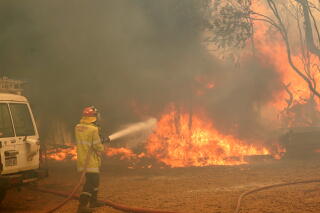 A firefighter attends to a fire near Wooroloo, northeast of Perth, Australia.