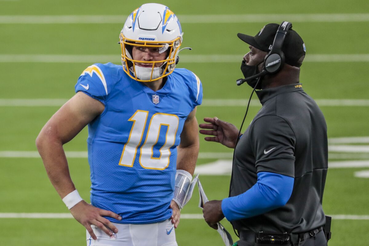 Chargers quarterback Justin Herbert speaks with coach Anthony Lynn.