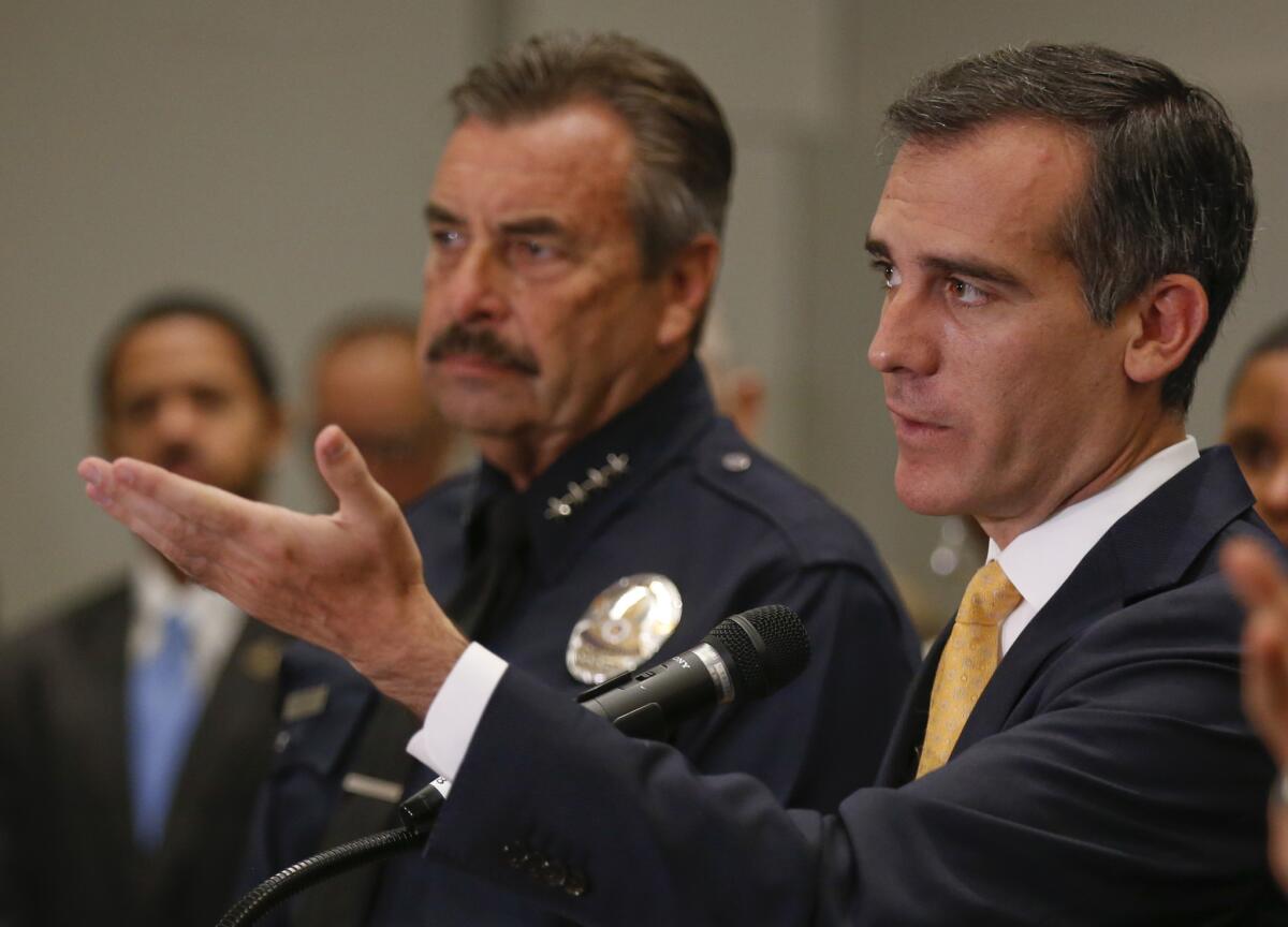 Los Angeles Mayor Eric Garcetti, right, and LAPD Chief Charlie Beck discuss the city's midyear crime report in July 2015.