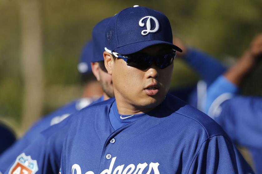 Hyun-Jin Ryu waits with teammates prior to a spring training baseball workout in Glendale, Ariz., on Feb. 22.