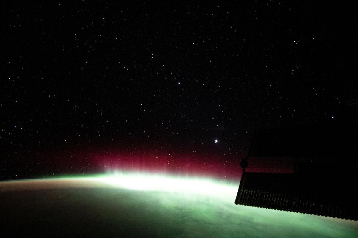 A green glow against a background of space and stars.