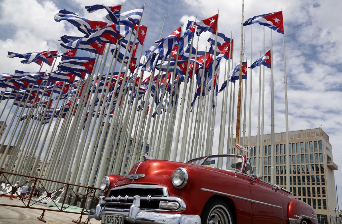 Classic American convertible car passes the U.S. Embassy in Havana