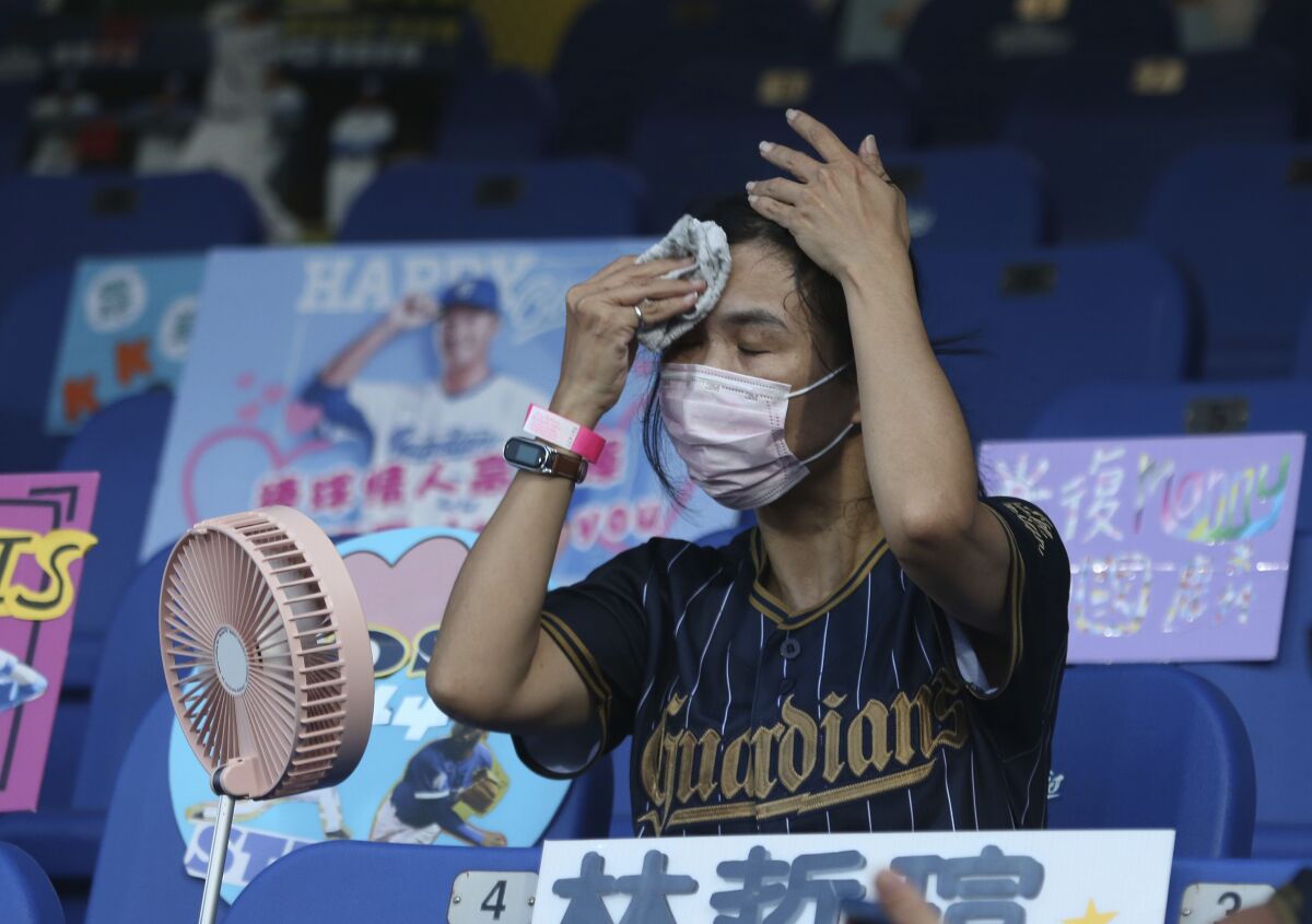 A spectator tries to cool off at a baseball game in Taiwan in May.