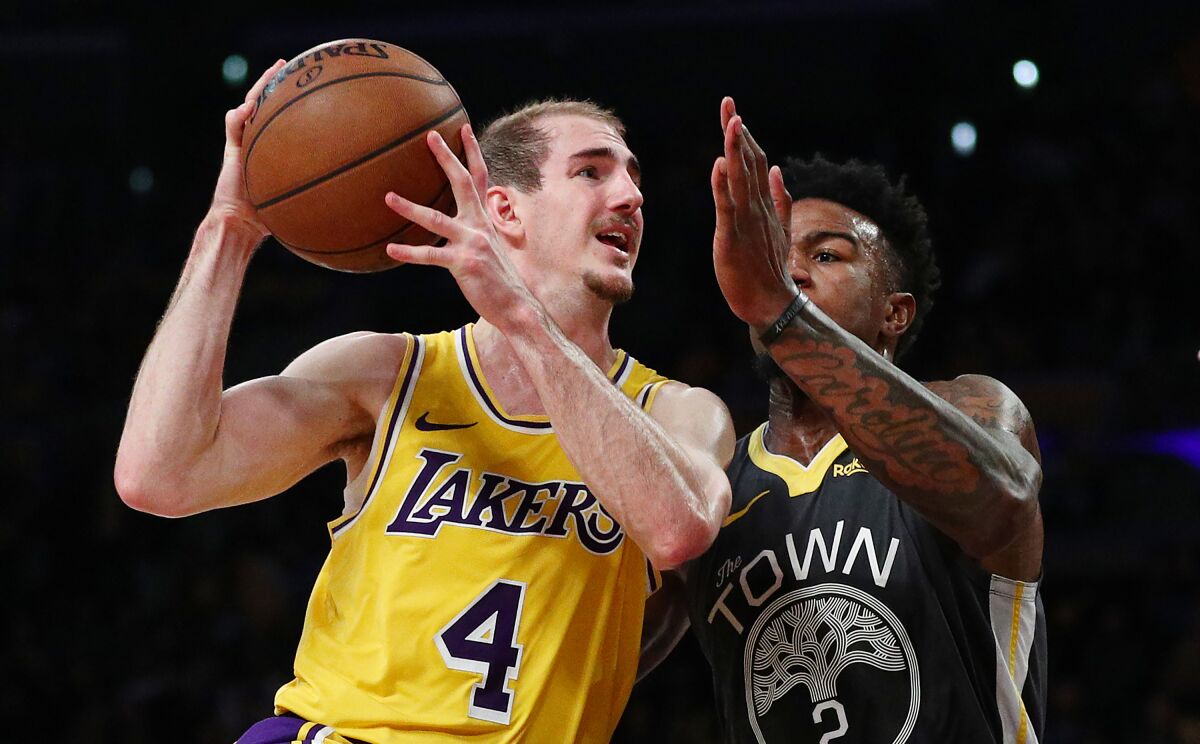 Lakers guard Alex Caruso, left, drives to the basket against Warriors forward Jordan Bell.