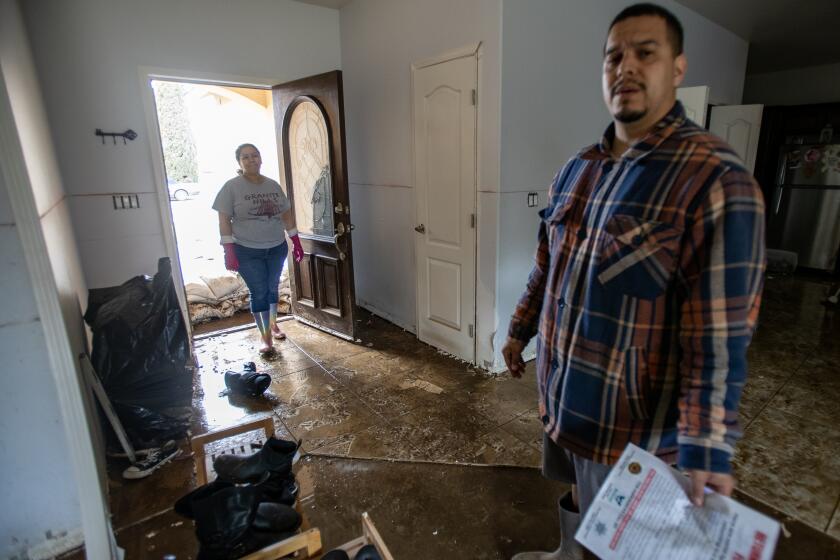 WOODLAKE, CA - MARCH 15, 2023: Joshua and Amada Diaz's home flooded after Tuesday's storm and they are in the process of removing all the wet wallboard as well as soaked belongings on March 15, 2023 in Woodlake, California. The flood water is contaminated and he said they probably won't be able to inhabit the home again until July. "Did city officials foresee or know about the extent of the flooding. If so why didn't they alert us," Diaz asked. "Why isn't the city helping us?" he added.(Gina Ferazzi / Los Angeles Times)