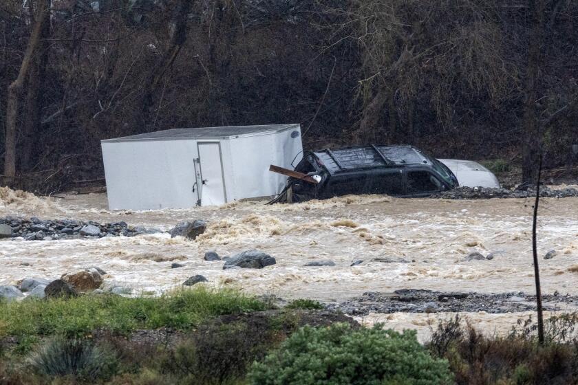 DEVORE, CA - FEBRUARY 5, 2024: An SUV hauling a box trailer is washed away in the Cajon Creek after the driver attempted to cross the flooded Keenbrook Road on February 5, 2024 in Devore, California. Two adults and a teenage son were rescues by the San Bernardino County Fire Department.(Gina Ferazzi / Los Angeles Times)