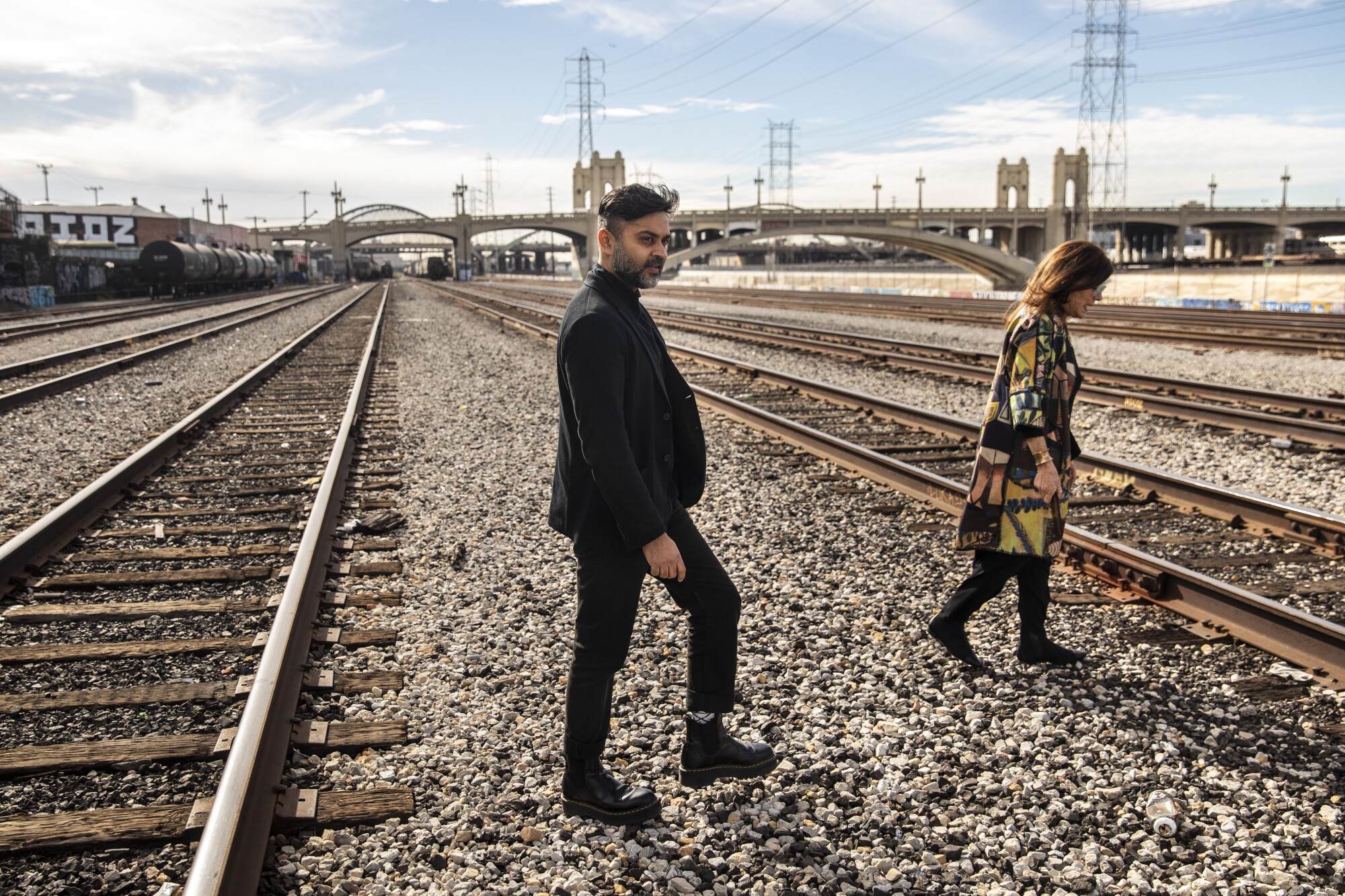 Kush Parekh and Mia Lehrer walk the railroad tracks outside their studio