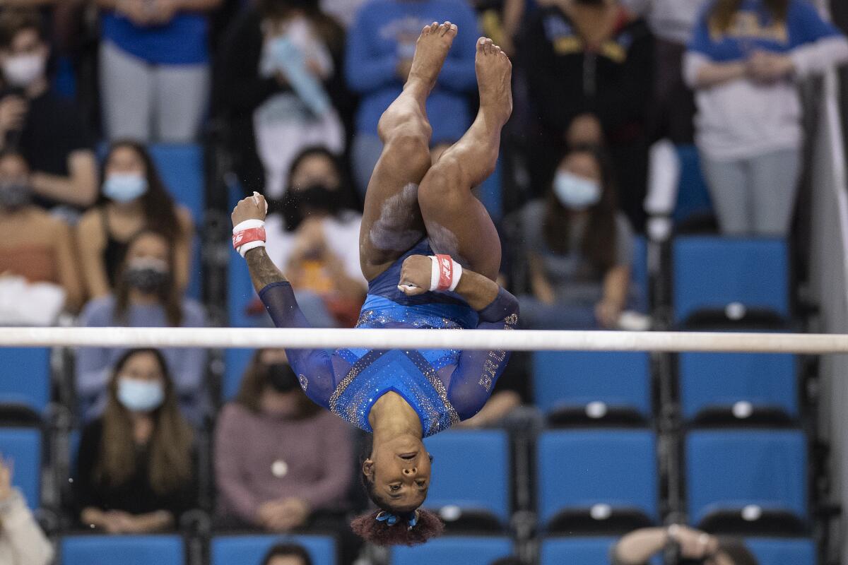 A gymnast does a backflip off the bars