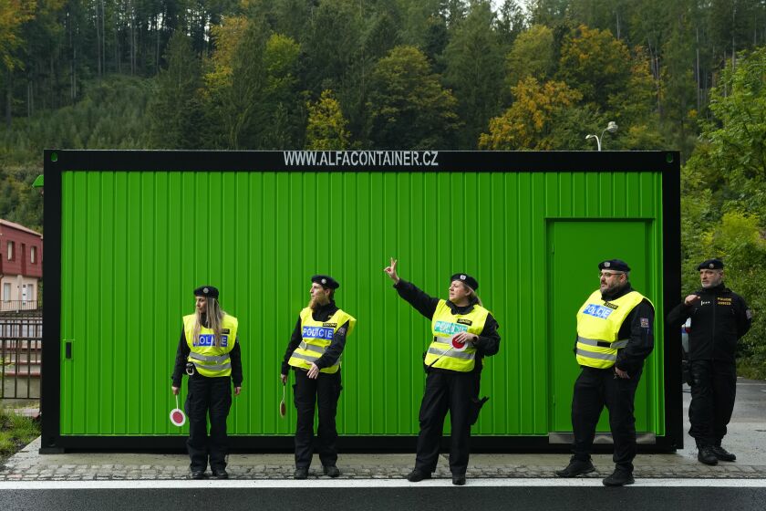 FILE - Czech policemen stand as they control cars and trucks at the border with Slovakia in Stary Hrozenkov, Czech Republic, Thursday, Sept. 29, 2022. The Czech government decided on Wednesday Feb. 1, 2023, to end border checks at its border with Slovakia that the country renewed last year amid a new way of migration. (AP Photo/Petr David Josek, File)