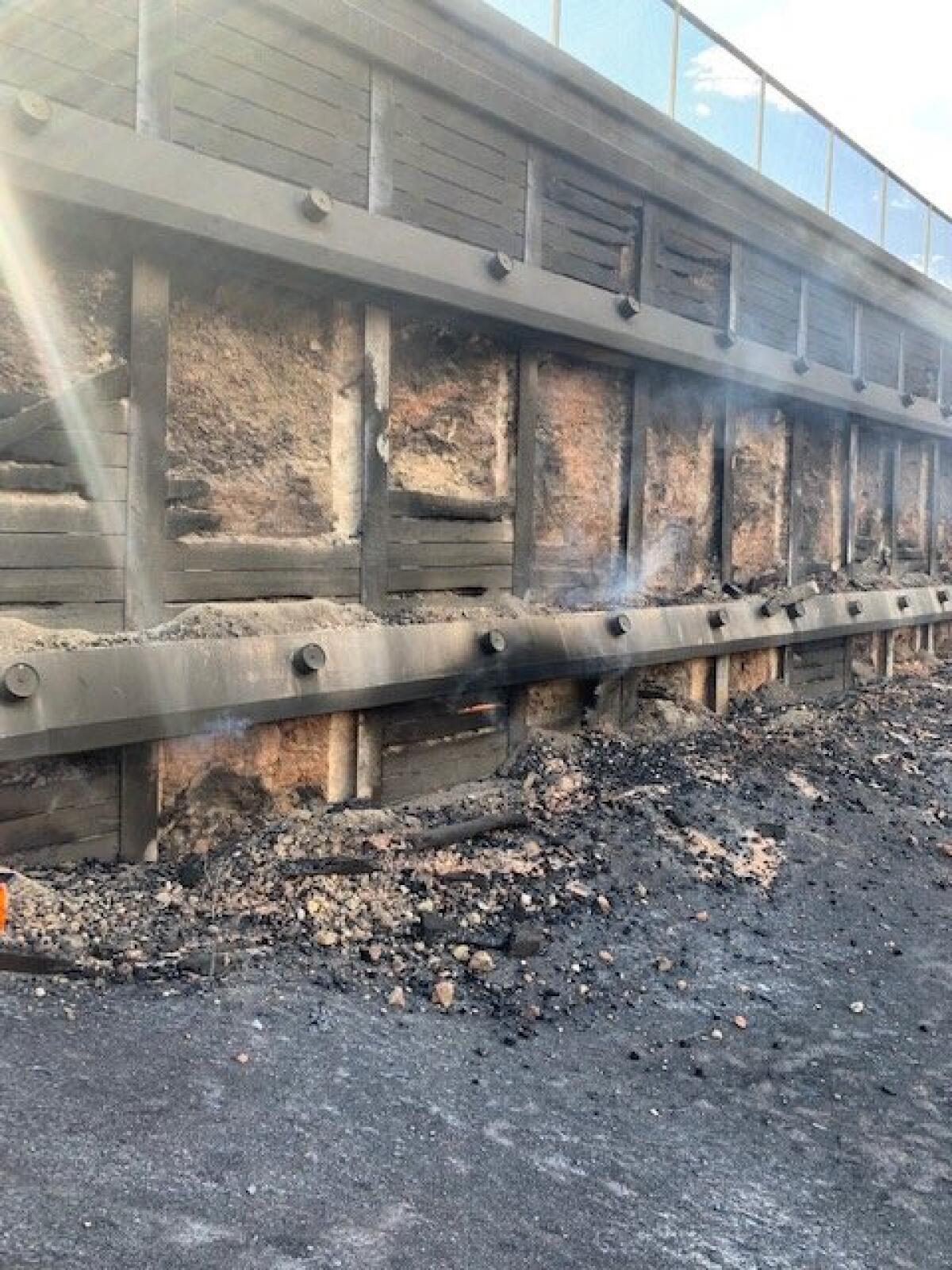 Fire damage to a freeway retaining wall.