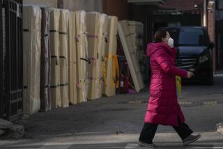 A woman wearing a face mask walks by empty coffins placed at a mortuary of a hospital in Beijing, Friday, Jan. 6, 2023. China is seeking to minimize the possibility of a major new COVID-19 outbreak during this month’s Lunar New Year travel rush following the end of most pandemic containment measures.(AP Photo/Andy Wong)