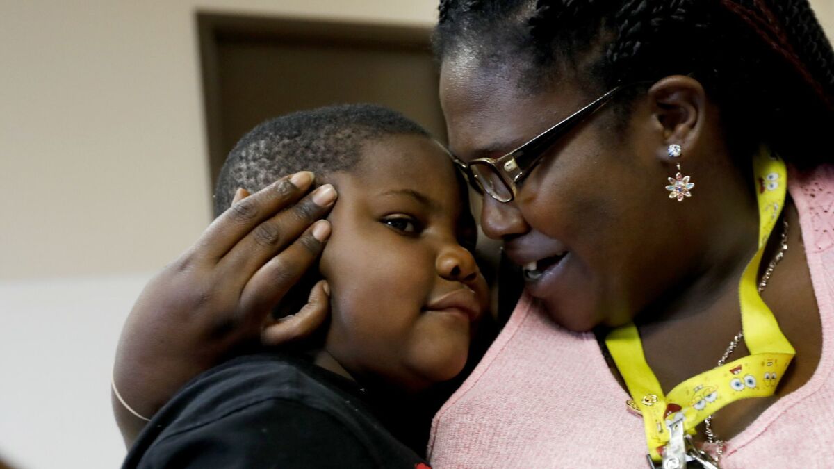 James Johnson, 4, and his mother Geneva Gwin embrace each other before dinner at the Union Rescue Mission in Los Angeles.