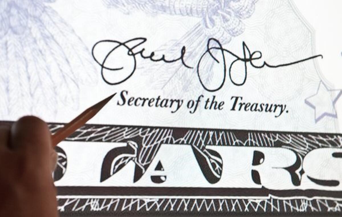 The Congressional Budget Office estimated that this year's deficit will amount to a mere $642 billion, down 24% from its earlier forecast of $845 billion. Above: A man points at a picture on Twitter showing U.S. Treasury Secretary Jacob Lew's new signature on a bank note.