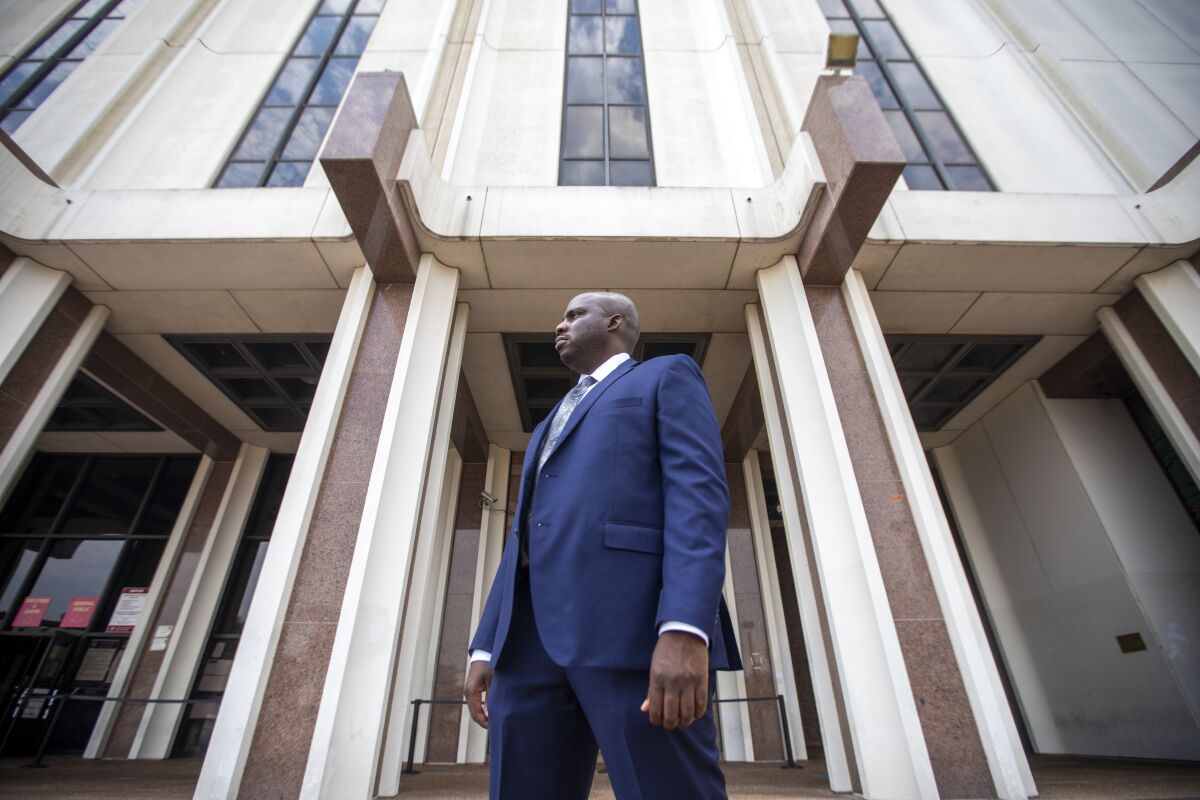 A man stands in front of the Compton Courthouse in Los Angeles.