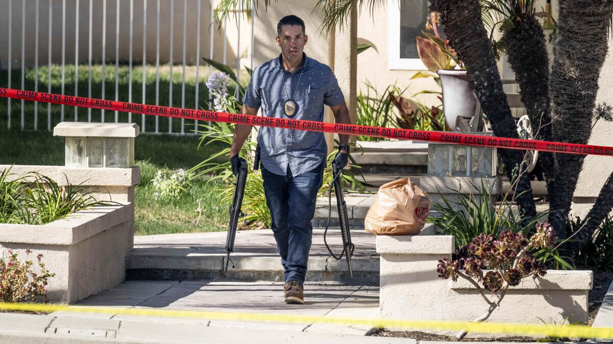 ARCHIVO - Investigadores retiran armas de una vivienda en Anaheim, California,