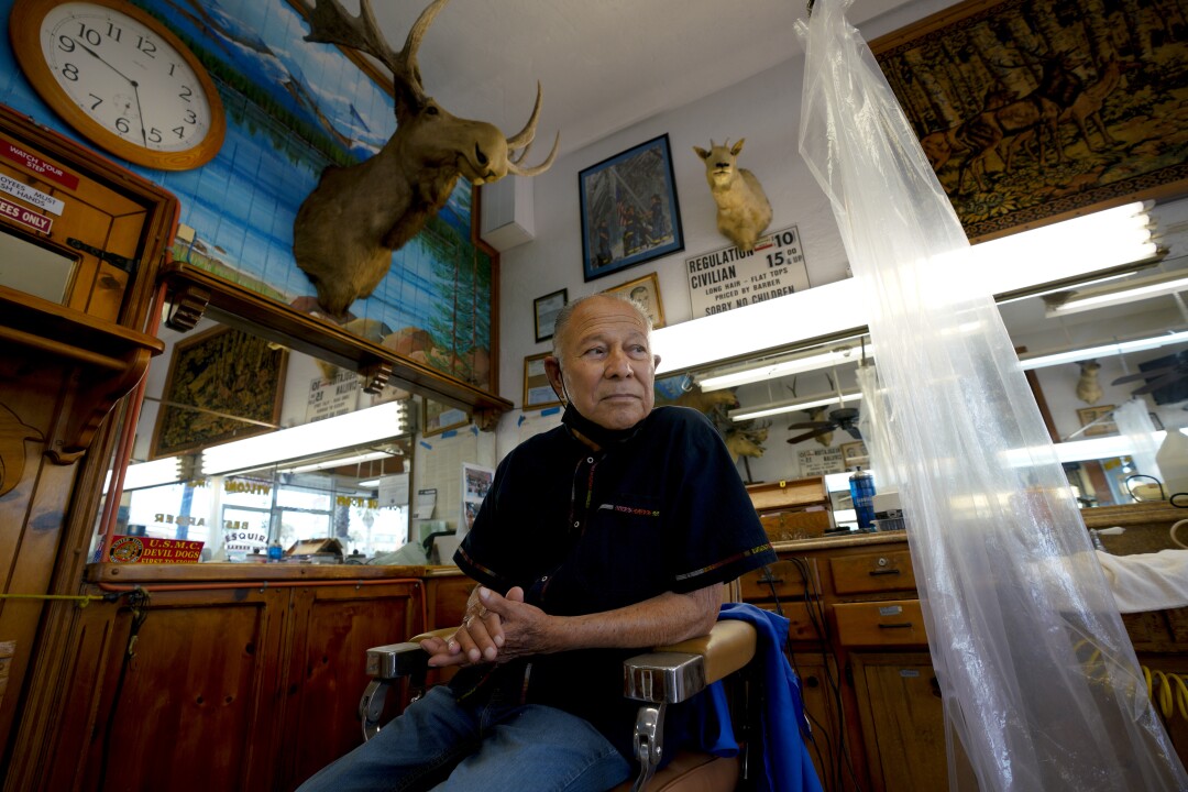  Johnny Gomez sits in one of the barber chairs.