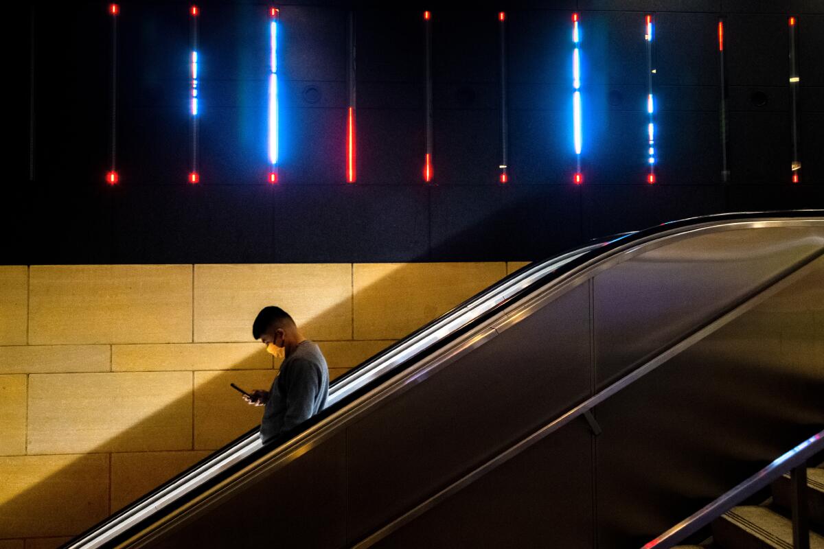 A commuter rides down an escalator at Union Station in downtown Los Angeles.