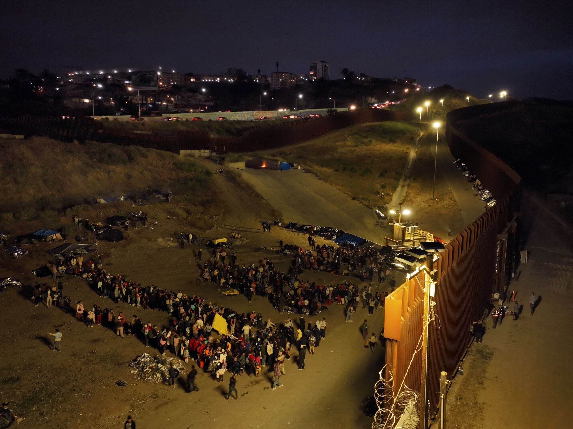Tijuana'dan Amerika Birleşik Devletleri'ne geçmek isteyen göçmenler şehrin kuzeyindeki bir bölgede bekliyor.