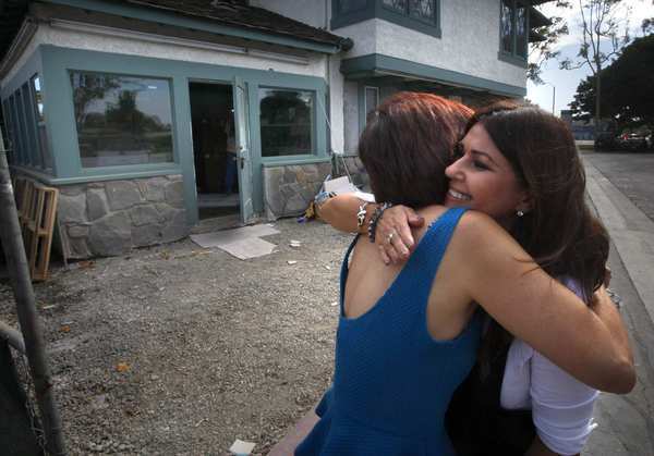 Irma Acosta, right, a survivor of last year's shooting attack at Salon Meritage and the shop's new owner, hugs designer Cynthia Pastor. The salon is being remodeled and is expected to reopen within weeks.