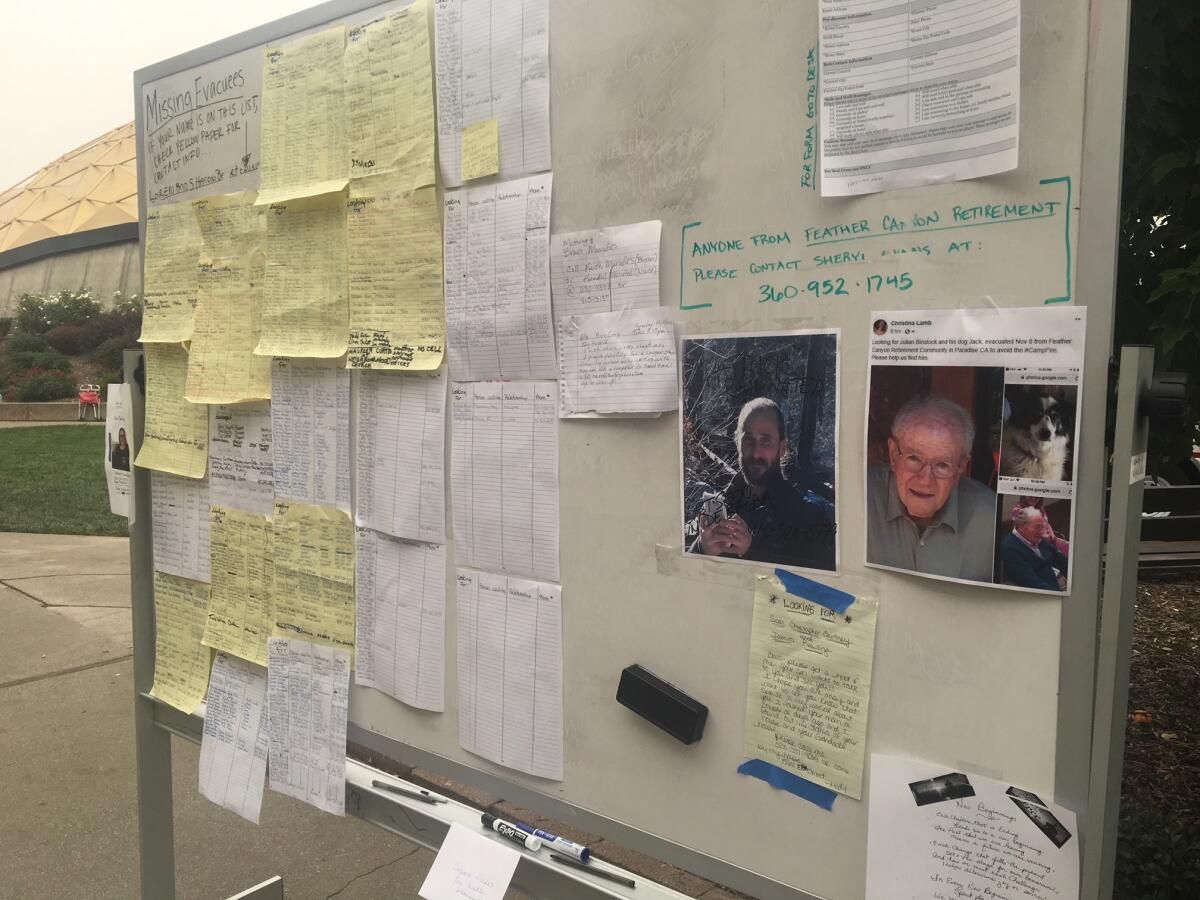 The names and photos of those missing in the Camp fire fill a white board at a church in Chico.