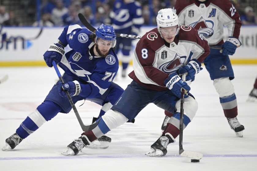 Colorado Avalanche defenseman Cale Makar (8) controls the puck next to Tampa Bay Lightning center Anthony Cirelli (71) during the third period of Game 4 of the NHL hockey Stanley Cup Finals on Wednesday, June 22, 2022, in Tampa, Fla. (AP Photo/Phelan Ebenhack)