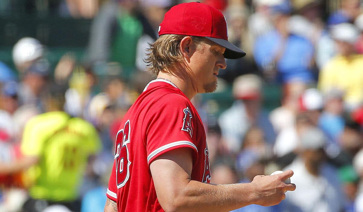 Angels pitcher Jered Weaver looks at the baseball after giving up a home run to the Dodgers' Austin Barnes on March 9.