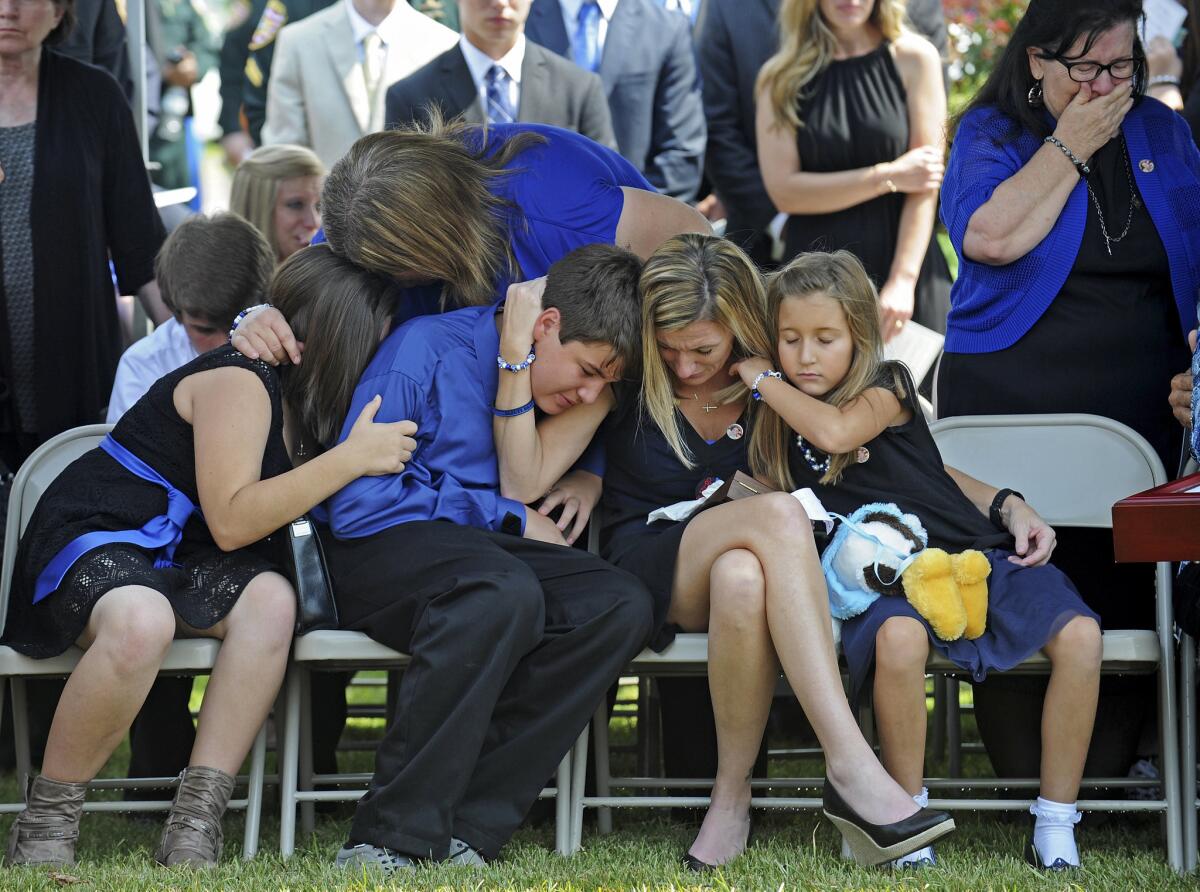 Tonja Garafola, widow of East Baton Rouge Sheriff's Deputy Brad Garafola, mourns with her children during his funeral at the Istrouma Baptist Church in Baton Rouge, La., on Saturday.