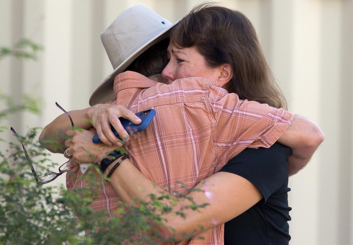 Two people hug after a shooting at the John W. Harshbarger Building on the University of Arizona campus in Tucson, Ariz., on Wednesday, Oct. 5, 2022. University of Arizona police say one person was shot and wounded on campus and authorities are searching for the suspect. (Rebecca Sasnett/Arizona Daily Star via AP)