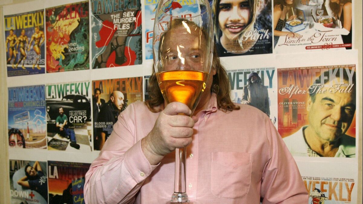 Jonathan Gold worked the city as a sort of culinary troubadour. Here, he holds up a giant glass of Champagne after winning the Pulitzer Prize in 2007 at L.A. Weekly, as if trying to protect his identity.