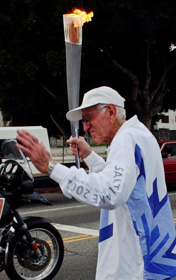 Louis Zamperini, 85 when this photo was taken in 2002, runs with the Olympic torch at 27th Street and Western Avenue in Los Angeles.
