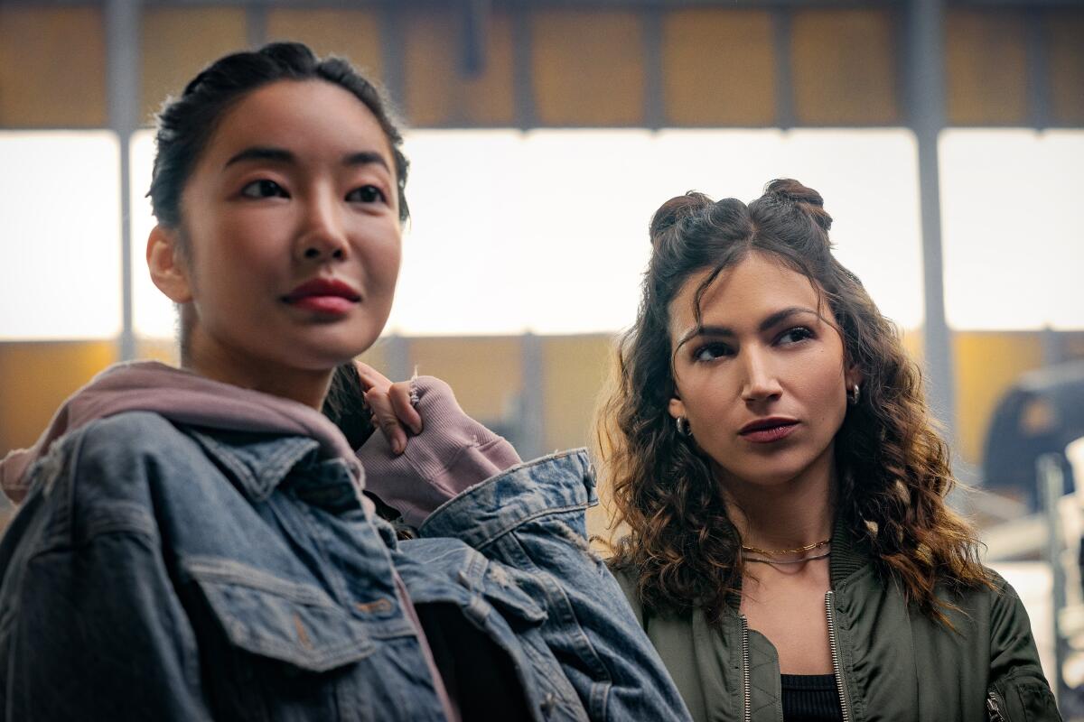 Yun Jee Kim and Úrsula Corberó, both in jackets, stand side by side in "Lift."