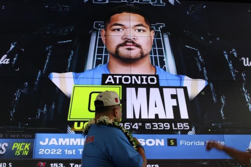 UCLA offensive lineman Atonio Mafi celebrates after being selected by the New England Patriots.