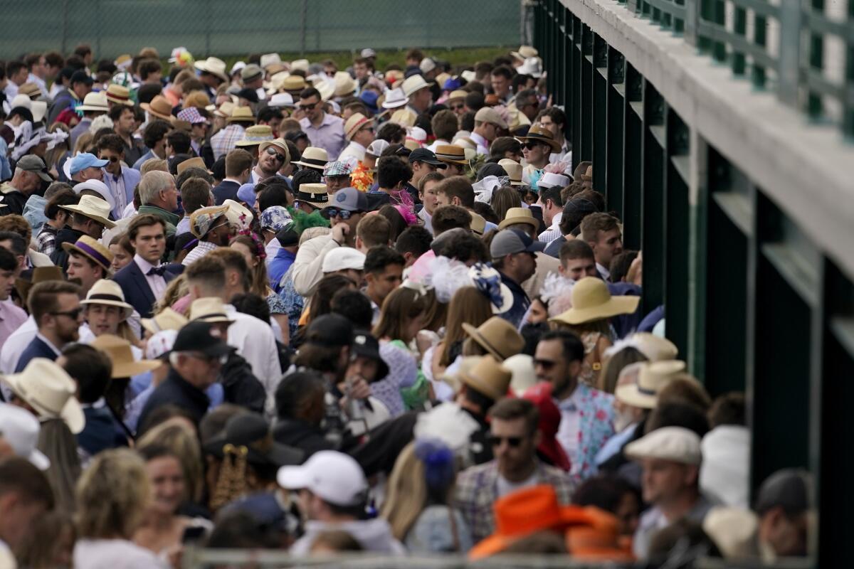 Fans stand at betting windows in the infield before the 148th running of the Kentucky Derby on Saturday.
