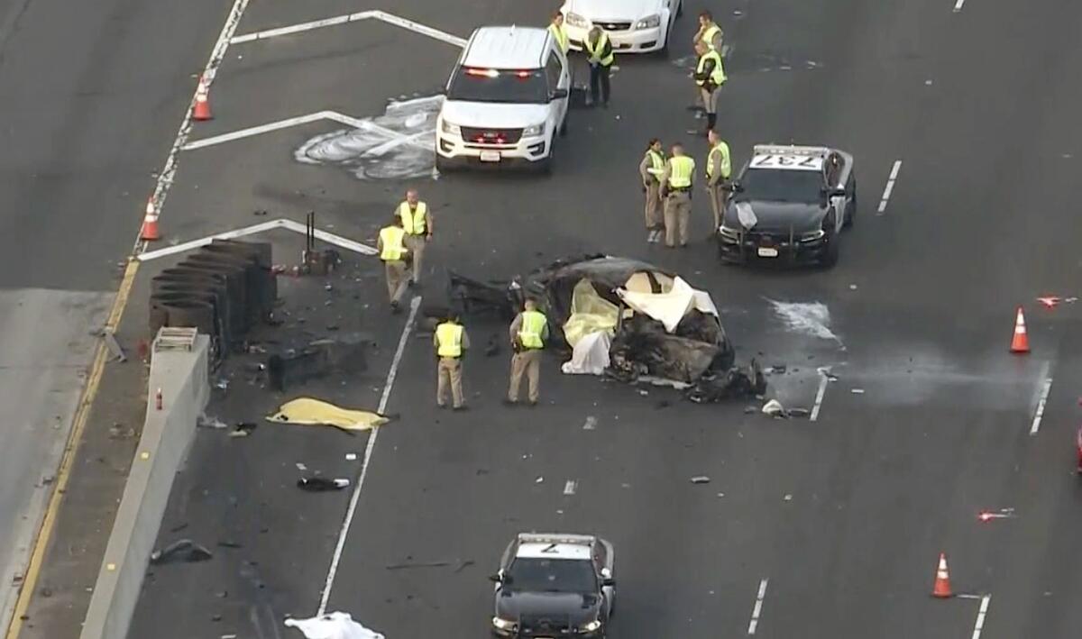 Aerial view of first responders around a burned vehicle on a closed freeway