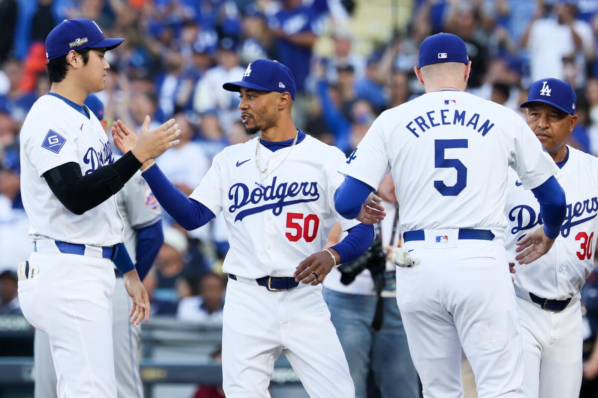 Dodgers stars Shohei Ohtani, left, and Mookie Betts greet one another during player introductions.