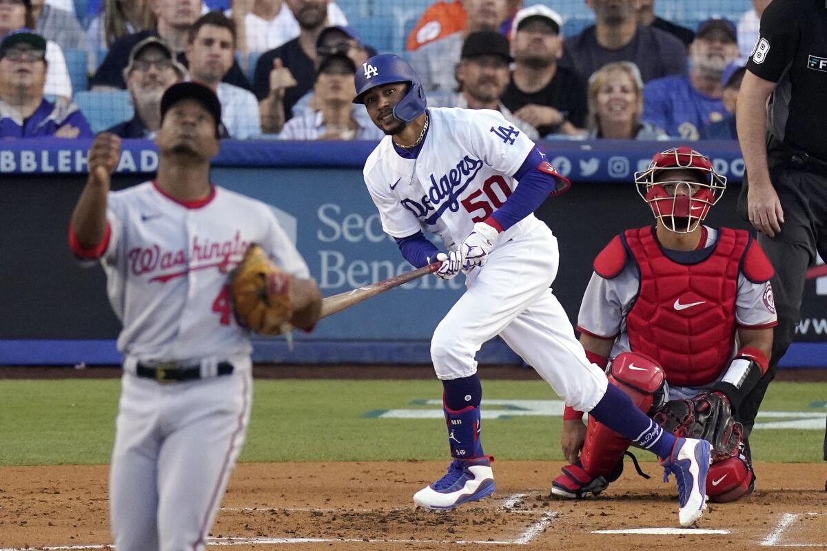 Dodgers' Mookie Betts hits a solo home run as the Washington Nationals' Josiah Gray and Keibert Ruiz watch.