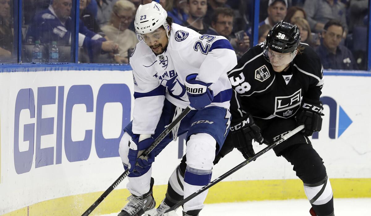 Tampa Bay Lightning right wing J.T. Brown, left, moves the puck ahead of Kings defenseman Paul LaDue during the second period.